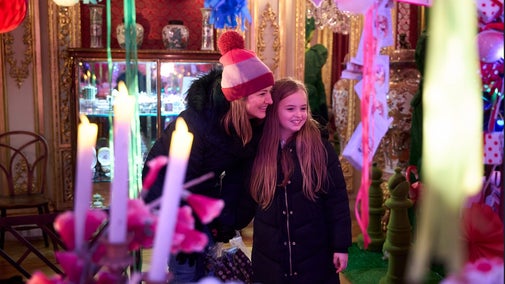 Alice's Christmas in Wonderland at Polesden Lacey 2025 - a woman and girl smile as they admire the Christmas decorations around them